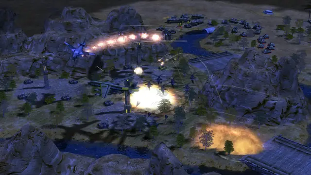 A blue-lit valley at night, aircraft firing on vehicles below and a fire on the ground